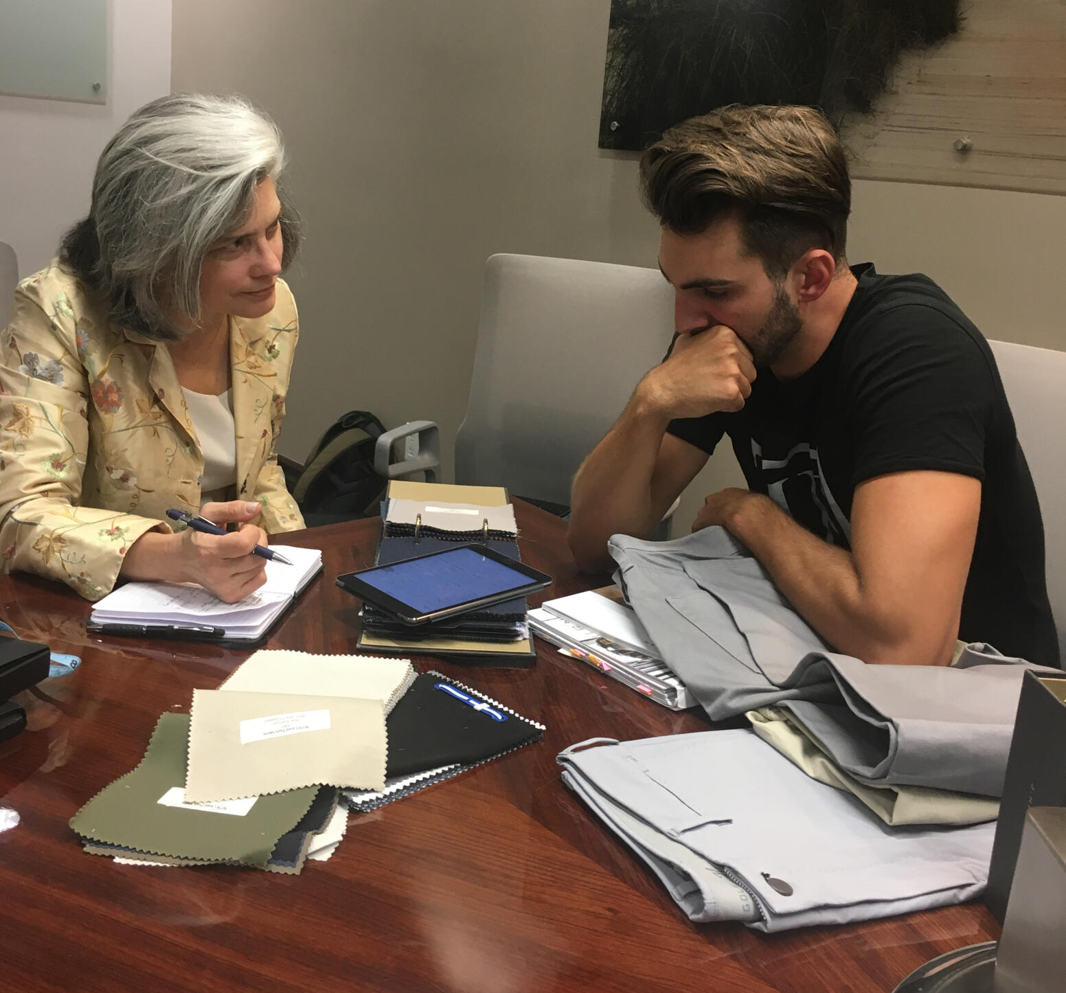Maria with client choosing styles and fabrics for J.Hilburn custom fitted suit.