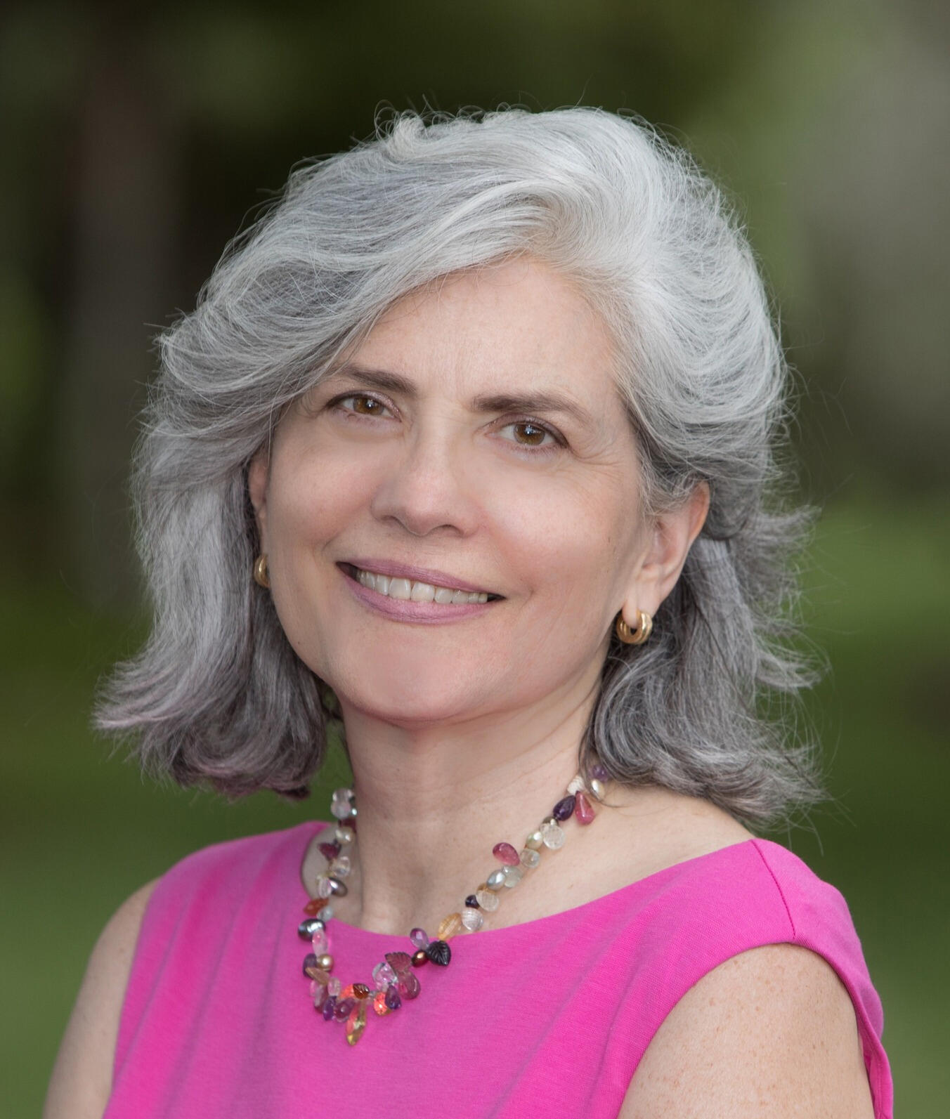 Headshot of Maria Rowley wearing a pink dress